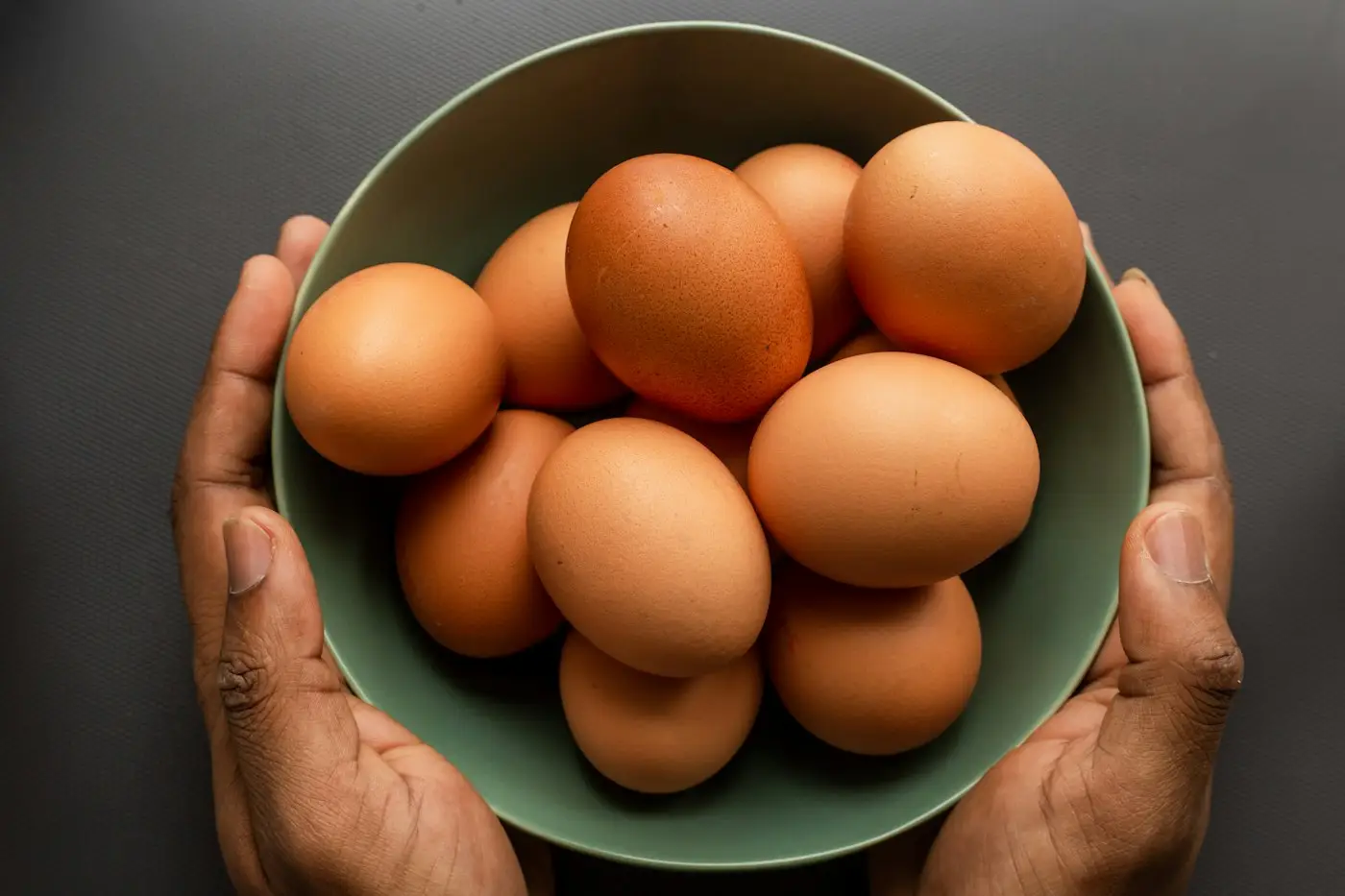 Bowl of brown eggs held in two hands