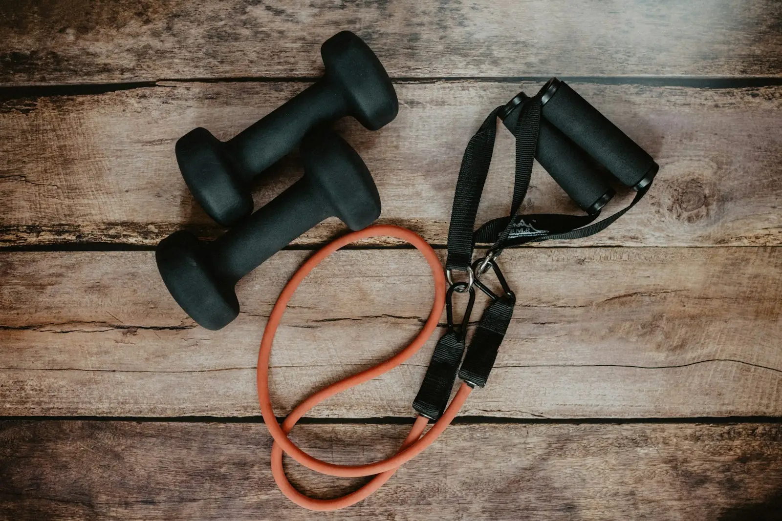 Dumbbells and resistance bands on a wooden floor