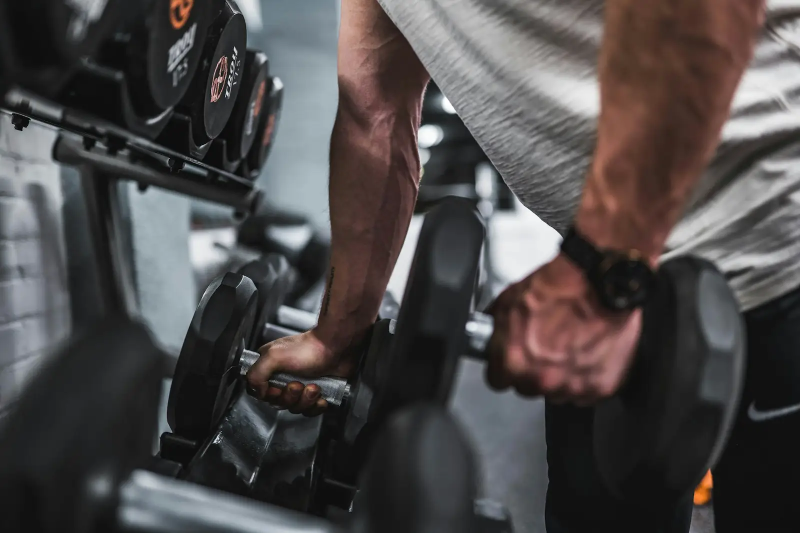 Man performing a barbell curl in the gym